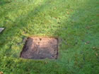 Cutting a square hole in the turf, slightly deeper than the paving stone, so the grass will grow over it