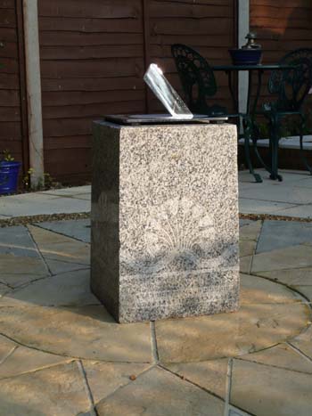 Staainless sundial on a four-legged plinth